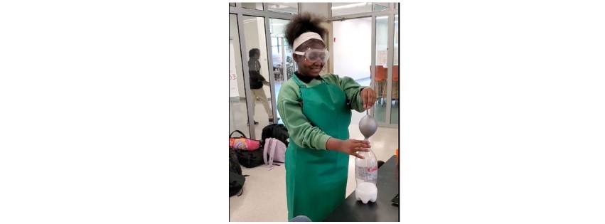 Student in green lab apron and goggles