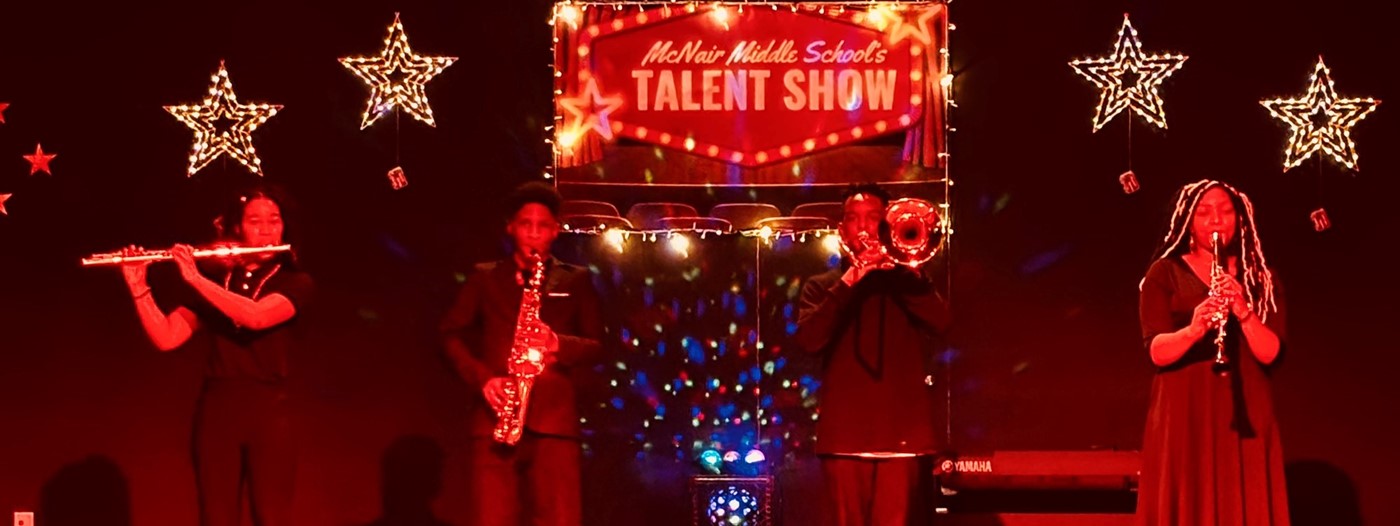 Four students playing musical instruments in the talent show.